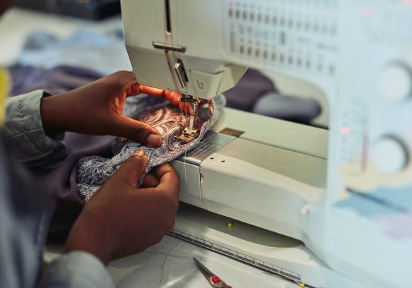 Cropped shot of a young fashion designer using a sewing machine in her workshop